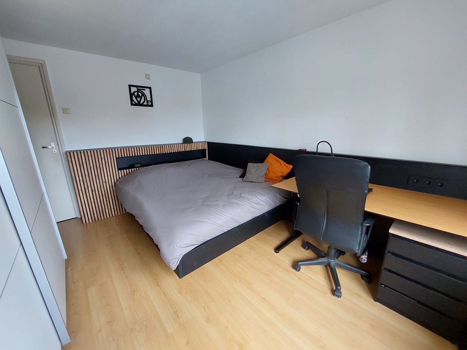 Slaapkamer met ingebouwd bed, zwart met houten bureau en kastcombinatie en lattenwand